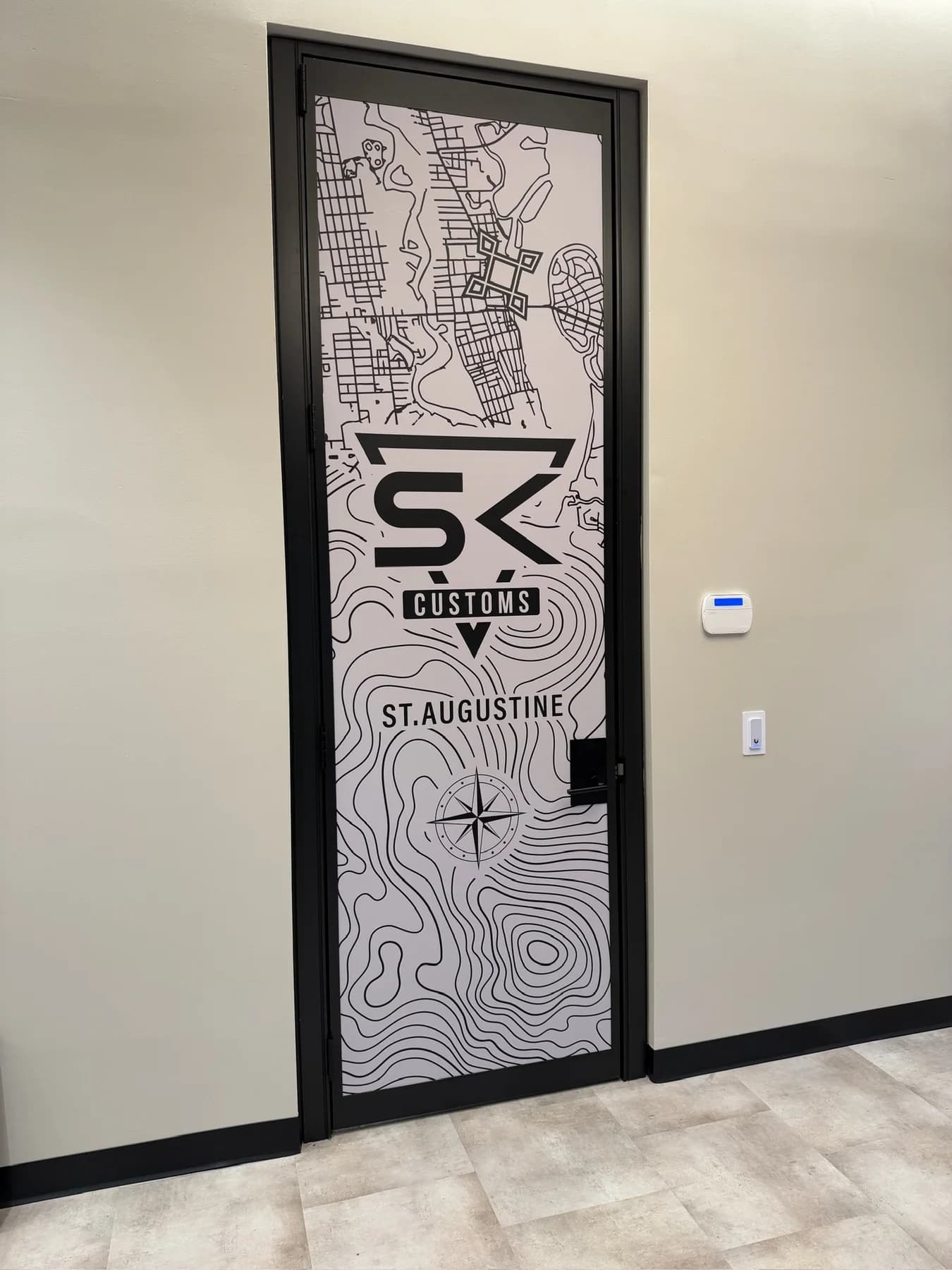 SK Customs St. Augustine topographic map graphic installed on an interior facility door