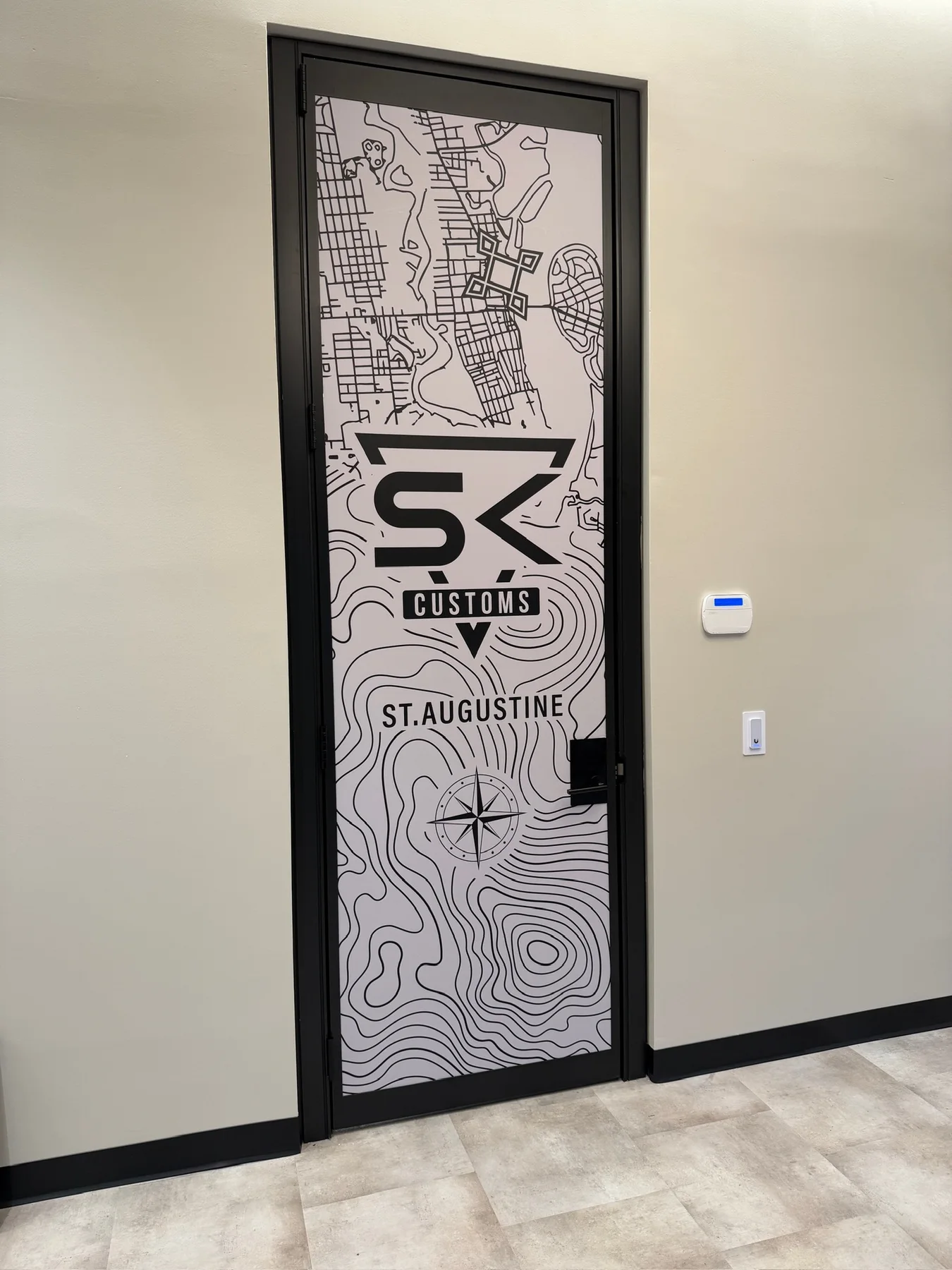 SK Customs St. Augustine topographic map graphic installed on an interior facility door